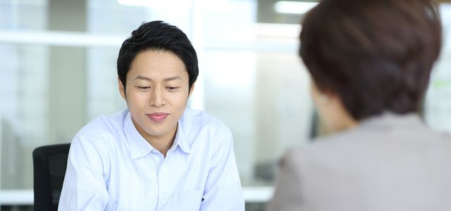 書類を見ながら対面で話をする男女