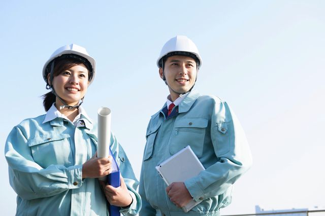 遠くを見つめる建設業者の男女