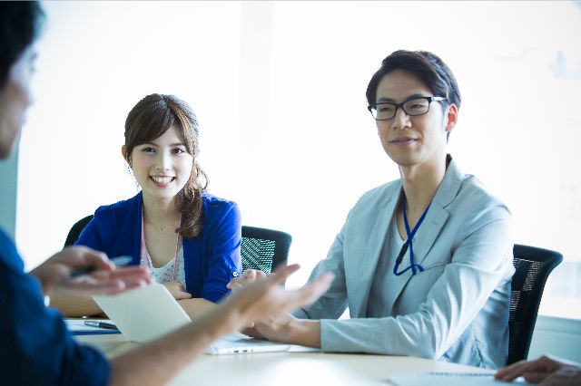 二人の男女に説明する年配の男性